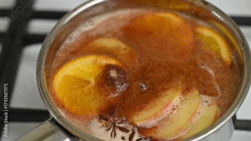 Fragrant mulled wine with spices and fruits in saucepan