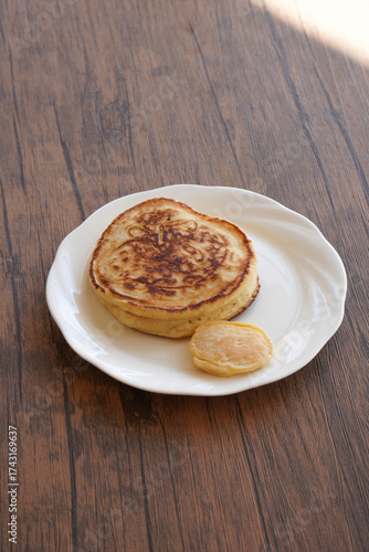 白い皿に乗ったパンケーキと小さいパンケーキ