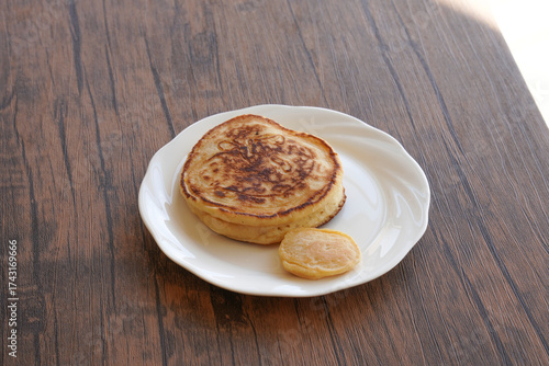 白い皿に乗ったパンケーキと小さいパンケーキ