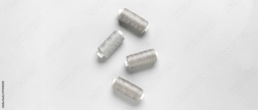 Fototapeta premium Spools of threads on light background, top view