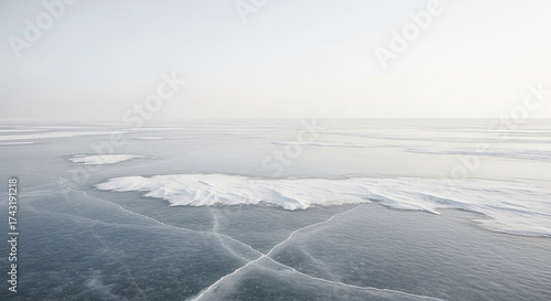 Frozen lake surface with cracks and snow, creating a serene and icy winter landscape with a sense of coldness and vastness