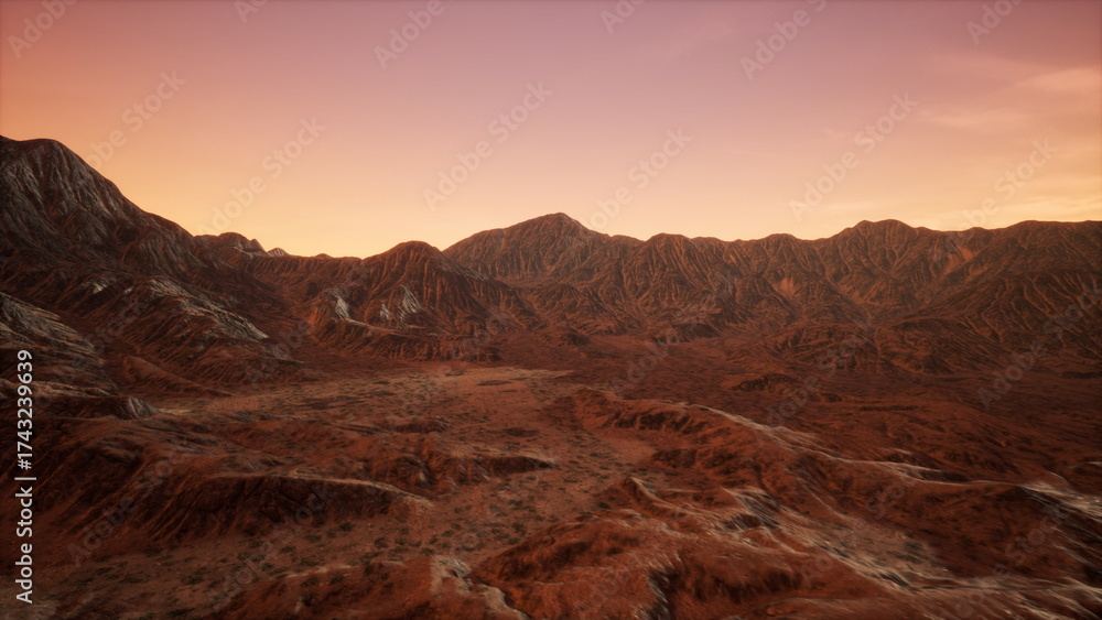 Naklejka premium Golden hues illuminate the rugged mountain peaks as the sun sets in the vast desert. Rocks and dry vegetation create an otherworldly atmosphere, showcasing natures striking beauty.