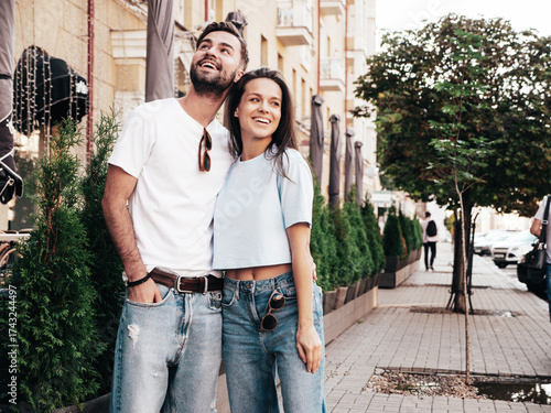 Smiling beautiful woman and her handsome boyfriend. Woman in casual summer jeans clothes. Happy cheerful family. Female having fun. Sexy couple posing in the street at sunny day