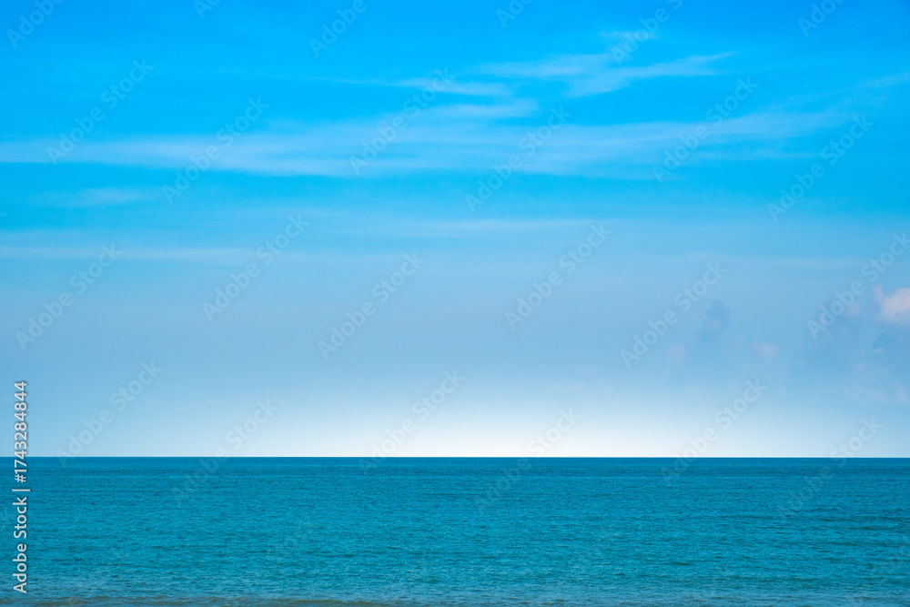 Fototapeta premium Nature of the ocean and blue sky Summer with sunshine, sandy beaches, clear blue waters sparkling against the blue sky. on an island with good ecology and environment Background for summer vacation