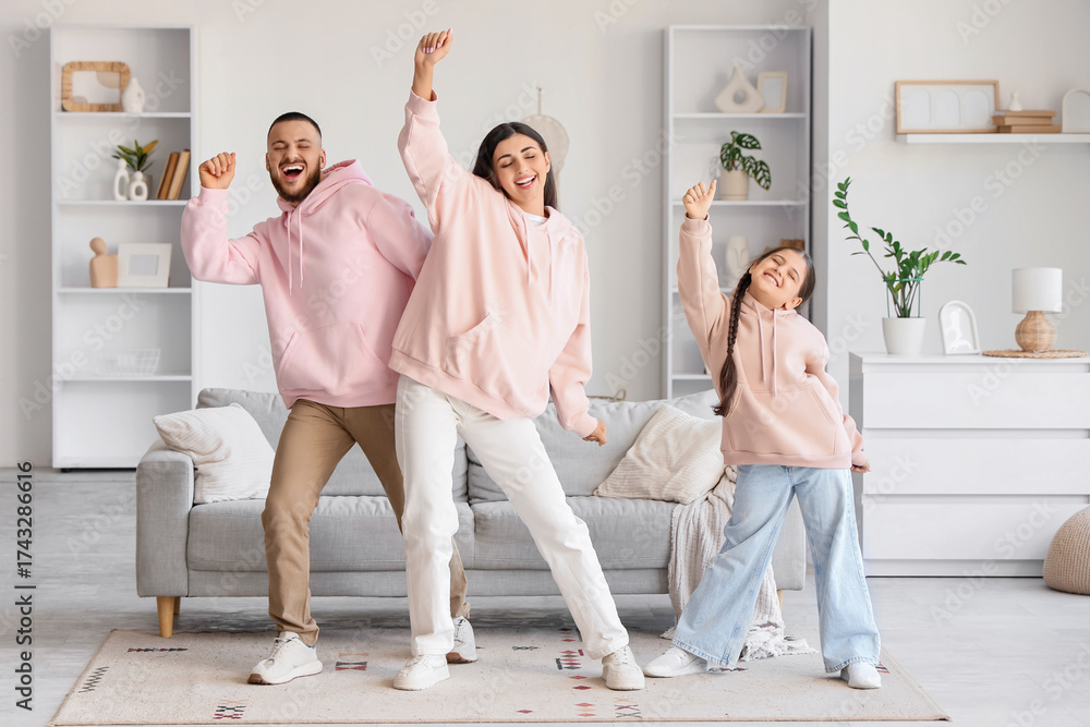 Obraz premium Happy parents with their little daughter dancing at home