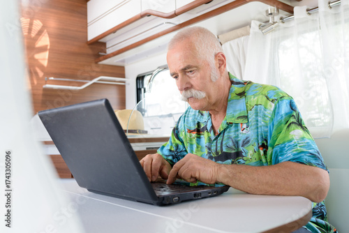 senior man using lapto in his van