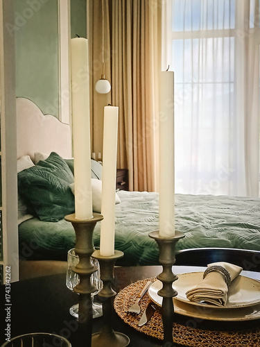 A beautiful interior in a classic style. Candles in a candlestick on a set table.