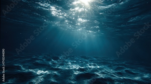 Underwater scene with sunlight penetrating the ocean surface, creating rays through deep blue water