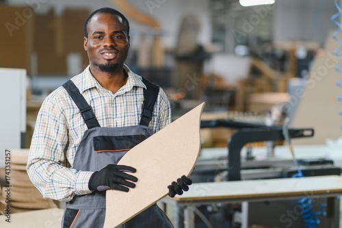 Foto Furniture maker holding wooden component in factory