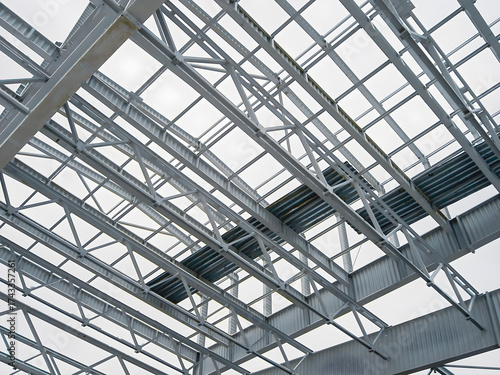 Steel structure of a building under construction against a cloudy sky.