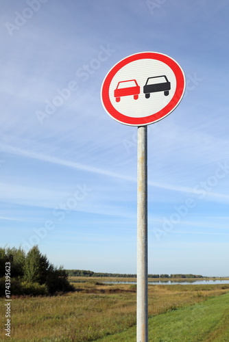 Overtaking is prohibited road sign in the evening against the sky