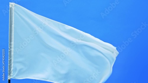Slow motion video of white flag waving on blue background