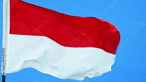 Slow motion video of Indonesia flag waving on blue background
