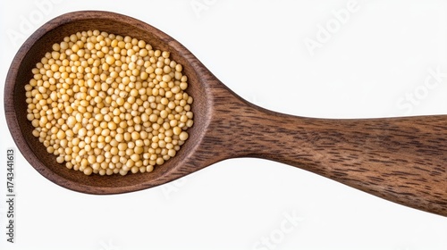 Mustard seeds in a wooden spoon, top view, spice and ingredient concept