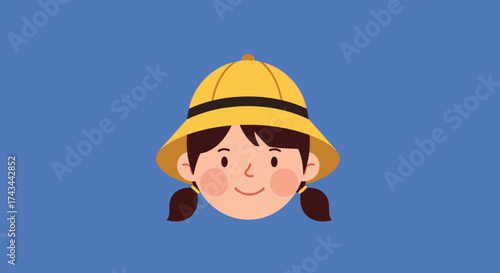A cute young child wearing a yellow hat and pigtails smiles happily.