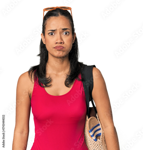 Tableau sur toile Young Filipina with beach bag blows cheeks, has tired expression