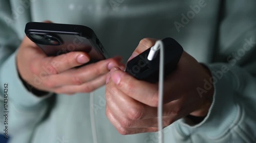 Charging a mobile phone with a portable charger.
A man connected his mobile phone to a smartphone to charge the phone's dead battery.