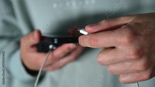 A man connects a charging cable to a mobile phone.
A dead smartphone battery.
Using a portable charger for a gadget.