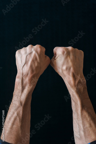 Принти на полотні Man with bulging veins on his arms against black background