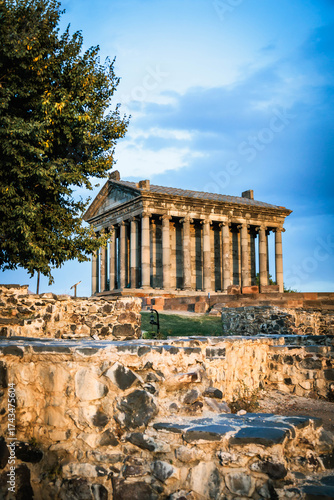 Wallpaper Mural Vertical view of the Temple of Garni in Armenia with foreground ruins and a large tree. Captured at sunset, highlighting the temple?s ancient columns and golden tones Torontodigital.ca