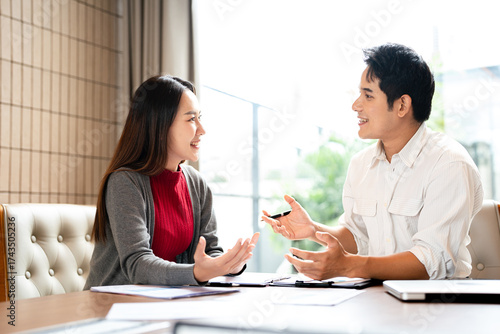 Two Asian businessman talk, consult, discuss working with new startup project idea presentation analyze plan marketing and investment in the office.
