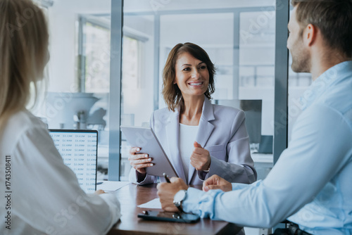 Wallpaper Mural Mature female mentor leader Latin woman collaborating with European young team doing banking analysing in office. Teamwork of professional business people working discussing financial trade strategy Torontodigital.ca