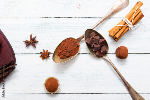 chocolate truffles, cocoa powder, broken dark chocolate on white wooden