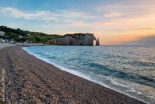The Porte d’Aval Cliff before the beach of Etretat at sunset, natural rock arch and beach of the alabaster coast, department of Seine Maritime, Normandie region, France.