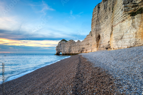 Sunset by the Amont Cliffs and its pebble beach at sunset, city of Etretat, alabaster coast, department of Seine Maritime, Normandie region, France.
