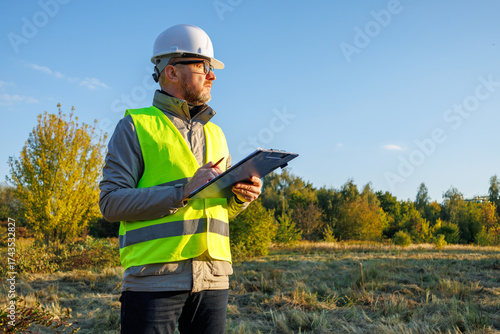 Male engineer inspects the condition of a new construction site. Work forestry inspector, environmental control. Ecologist conducts environmental monitoring soil analysis. 