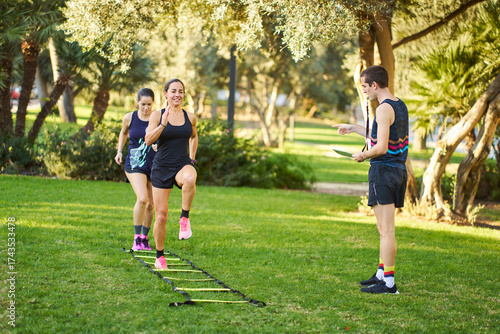 Women training with agility ladder outdoors personal trainer