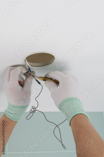 The master sets up the lighting and uses the device to measure the voltage, close-up