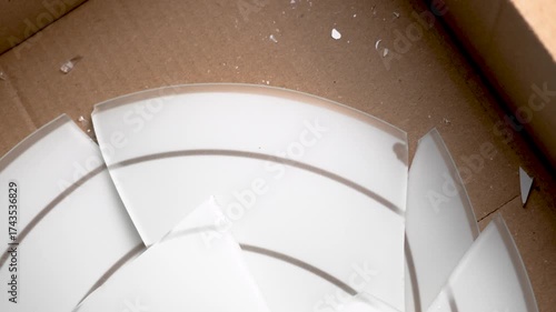 Fragile lamp broken into shards in cardboard shipping box. Failed delivery concept