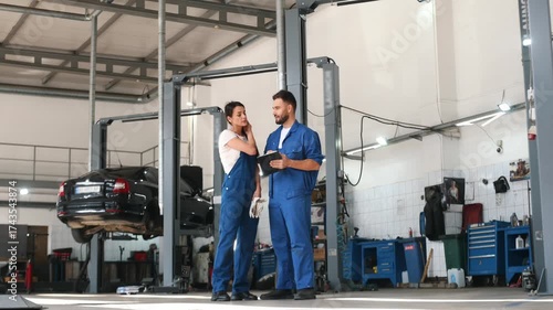 Auto repair shop employees are working together. Man and woman.