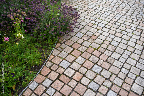 Mediterranean-style urban garden with stone paths and blooming vegetation in Hamburg, designed as a calm outdoor space integrating greenery, architecture and sustainable landscape design