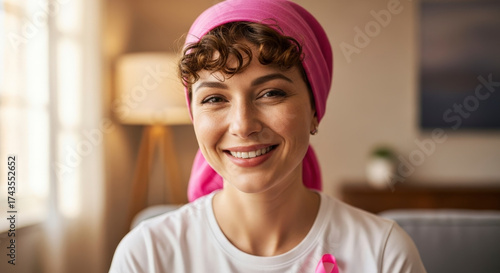 Smiling woman with pink headscarf promoting breast cancer awareness and support for survivors