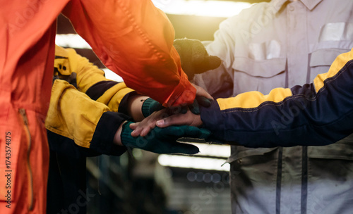 Teamwork among industrial workers joining hands in unity 