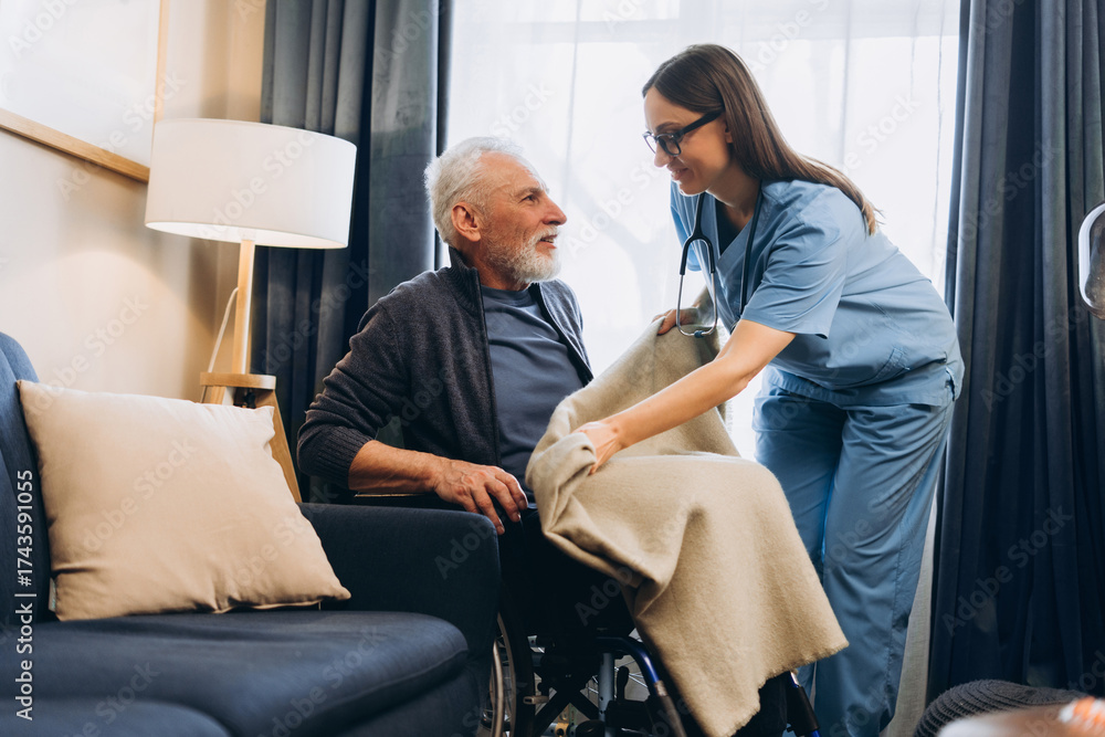 Obraz premium Happy, smiling woman, nurse supporting senior man in wheelchair giving care