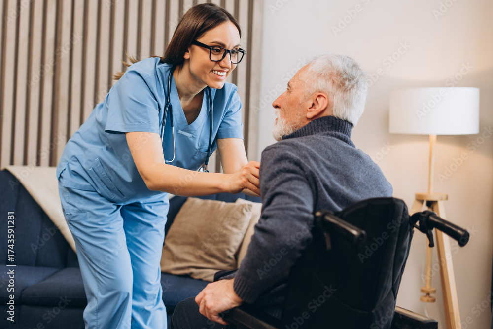 Obraz premium Nurse caregiver providing assistance to senior man in wheelchair at home