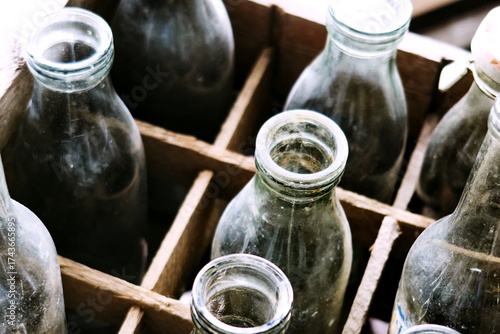 Anciennes bouteilles en verre dans un casier en bois.