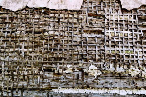 Détail de mur en torchis. Baguettes de bois plates tressées servant de support à l'enduit.