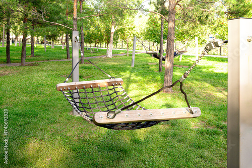 Hammock in green public park with trees for outdoor rest