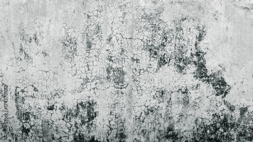 Gritty black and white textured background of a weathered and decaying old concrete wall with peeling paint and cracks for a grunge effect