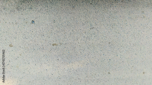 Close-up shot of a textured, weathered surface with subtle color variations a...