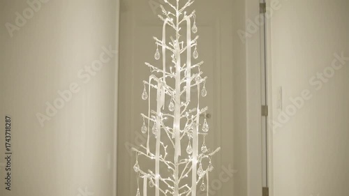 Elegant, minimalist white Christmas tree adorned with delicate ornaments, creating a festive and stylish holiday ambiance indoors