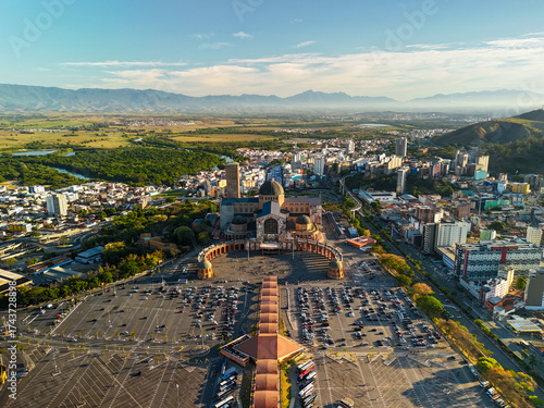 aerial view of the Basilica of the National Shrine of Our Lady Aparecida in Brazil during sunrise with mountains and greenery at distance