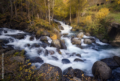 Riquerna River Cascades Through Vibrant Autumn Foliage in La Vall Fosca, Catalonia