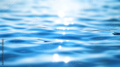 A close-up view of rippling, translucent blue water, showcasing the subtle light reflections and smooth surface textures.
