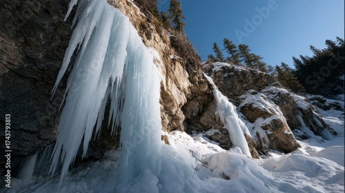 Wallpaper Mural Frozen waterfall clings to rugged cliffside, embodying nature's icy artistry, evoking Winter Solstice magic and Siberian Taiga's chill Torontodigital.ca