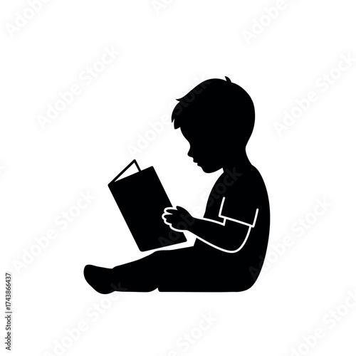 Silhouette of a young child absorbed in reading a book.